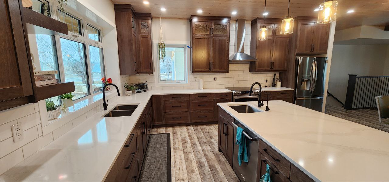 A kitchen with stylish brown cabinets with white countertop and under-cabinet lighting.